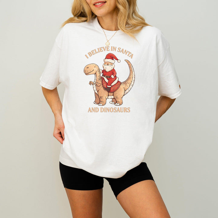 Unisex Baumwoll-T-Shirt "I Believe In Santa & Dinosaurs" | Lustiges Weihnachtsmann reitet auf Dino-Shirt-FaceeCo