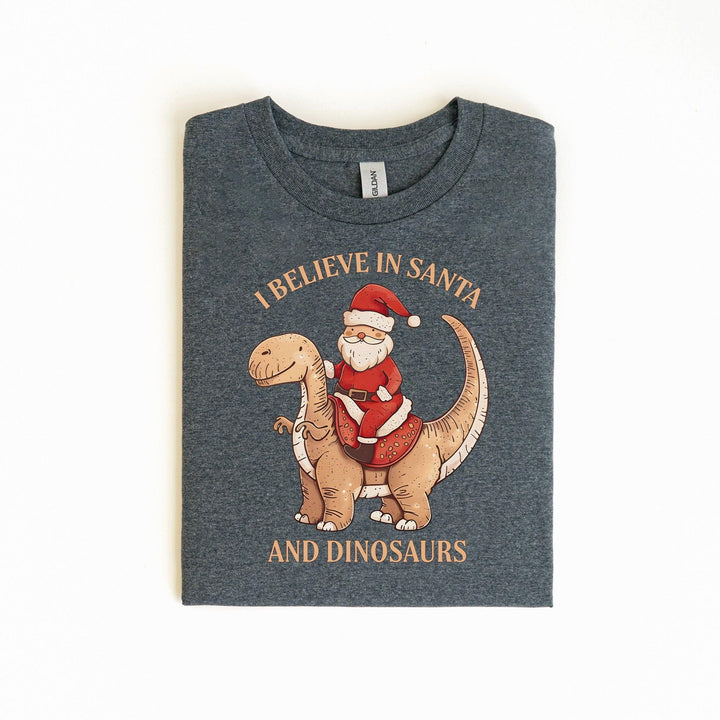 Unisex Baumwoll-T-Shirt "I Believe In Santa & Dinosaurs" | Lustiges Weihnachtsmann reitet auf Dino-Shirt-FaceeCo