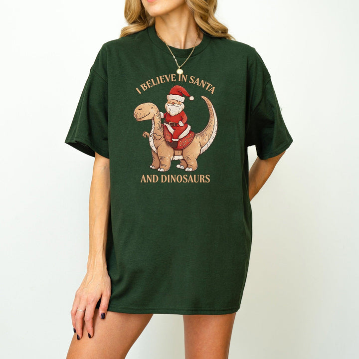 Unisex Baumwoll-T-Shirt "I Believe In Santa & Dinosaurs" | Lustiges Weihnachtsmann reitet auf Dino-Shirt-FaceeCo