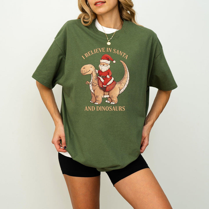 Unisex Baumwoll-T-Shirt "I Believe In Santa & Dinosaurs" | Lustiges Weihnachtsmann reitet auf Dino-Shirt-FaceeCo