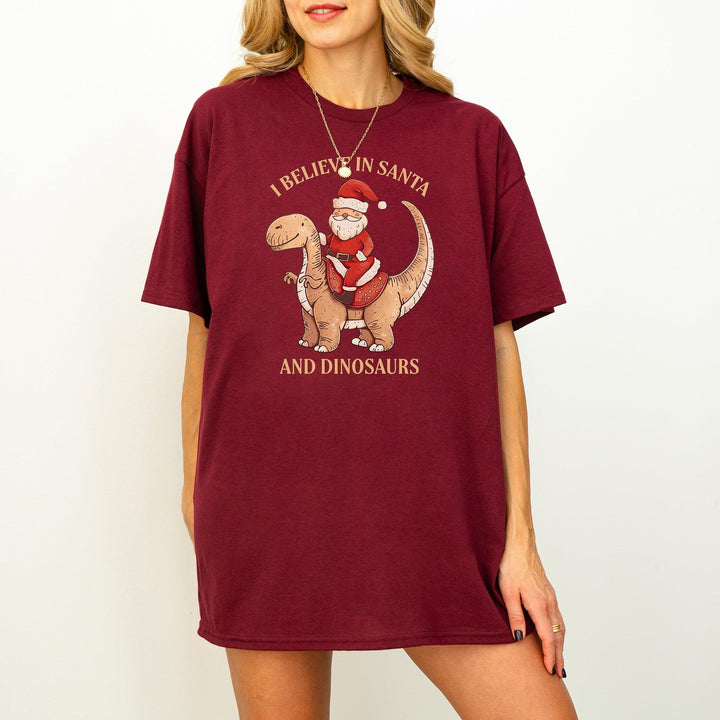 Unisex Baumwoll-T-Shirt "I Believe In Santa & Dinosaurs" | Lustiges Weihnachtsmann reitet auf Dino-Shirt-FaceeCo
